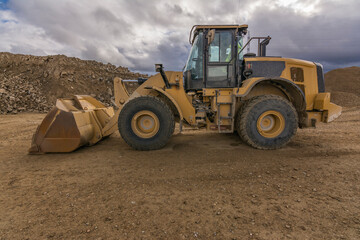 Obraz premium Yellow excavator moving earth at a construction site
