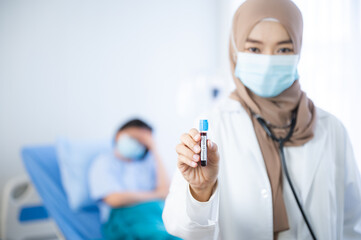 The beautiful Muslim doctor wear hijab works at the hospital to take care the elderly patient. The concept of aging society under the COVID-19 pandemic situation.