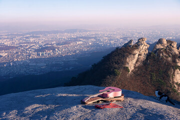 Panoramic view of Seoul city from Bukhansan Mountain. Hiking uphill with a guitar. Self-isolation...