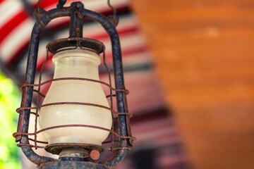 old iron kerosene lamp for traditional lighting base with copy space on blurred background