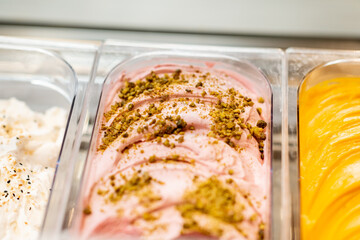 Close-up of ice cream with different flavors in the refrigerator on a shop window
