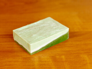 Green handmade soap. Soap in packaging on wooden background