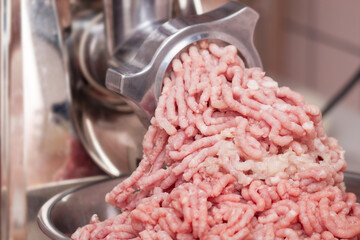 Close up of minved pork meat with onion coming out from grinder.