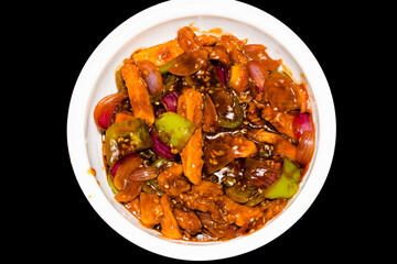 honey chilli potatoes in a spicy sauce, sesame seeds and green onions close-up, horizontal top view from above, isolated on black
