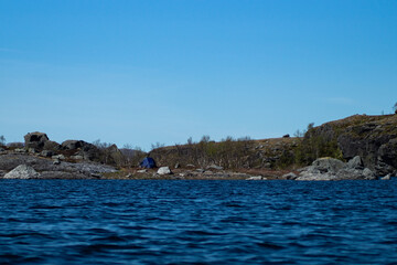 Campsite outdoors with lake and ten, blue sky and tree