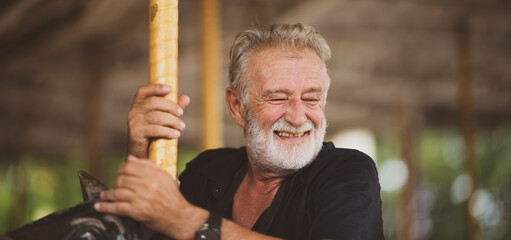 Senior father happy in theme park, old man smiling and enjoy relaxing at an amusement theme park