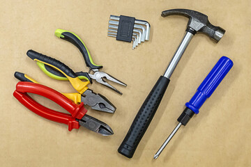 tool kit pliers, hammer and multi-faceted wrench on a light background