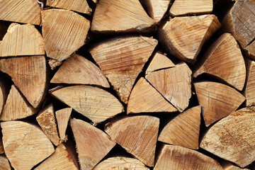 Hardwood firewood split logs stacked quarters in a pile, an end view.