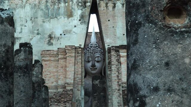 Zoom in From the outside of the temple to the face of Big buddha image at Wat Sri Chum in Sukhothai Thailand. Sukothai historical park, Unesco world heritage.