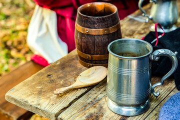 brown beer mug made of clay and aluminum pair, dishes for a pub on a wooden table
