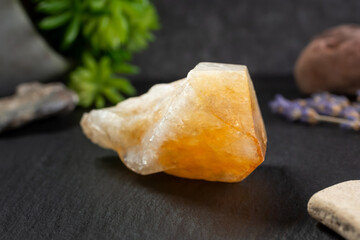 A closeup view of a citrine crystal, in a still life setting.