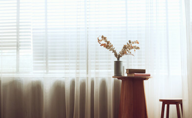 Living room with wooden table and chair have dry flower in vase and book on the table. Retro style