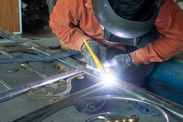 Welders are welding all parts of the construction of stainless steel doors.