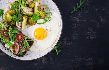 Breakfast with fried egg, broccoli, mushrooms and tomato sandwich. Healthy balanced food. Top view, overhead, copy space