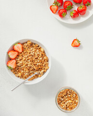 Homemade granola in a bowl with fresh strawberries, nuts and yogurt. Healthy and delicious Breakfast. The concept of summer food. Top view, selective focus.