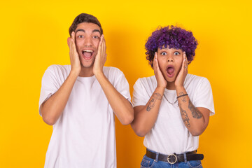 young couple with expression of surprise and amazement isolated