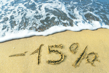 -15% percent discount is drawn on the sand on the beach. Discount on vacation at the sea.
