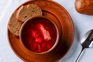 Traditional Ukrainian Russian soup, Borscht. Beetroot soup in bowl on wooden board and rustic wooden background