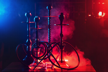 hookahs on the table with smoke and red and blue light in the lounge cafe