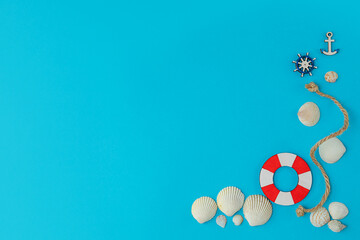 Summer composition in marine style, with shells and wooden figures on a blue background. Concept of summer vacation at the sea. flat lay, copy space.