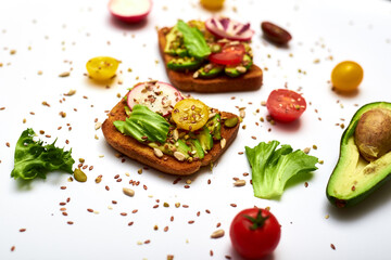 Toasts with vegetables, avocado, tomatoes, a set of seeds on a white background. Healthy food, diet concept.