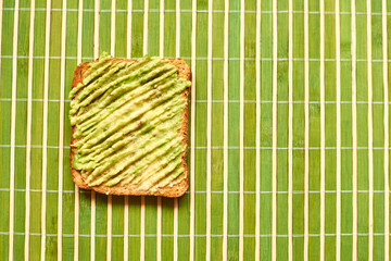Toast with avocado on a green background.