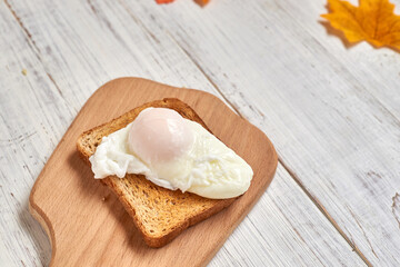 Fototapeta na wymiar Toast with poached egg on a white plate.