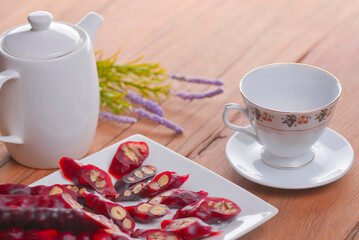 Tasty oriental sweets. Caucasian delicacy churchkhela - georgian nut treats. Served with a glass of tea and a tea pot.