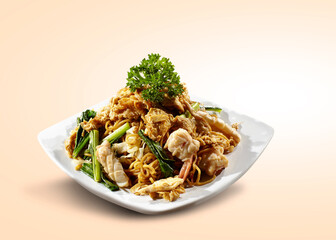 Seafood Fried Noodle is served on a plate with parsley garnish. Isolated fried pasta noodle food.