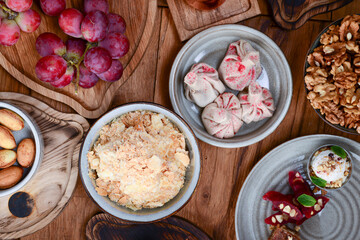 Sweet khinkali with cherry, churchhela, ice cream and nuts served on a wooden table. Traditional Georgian desserts