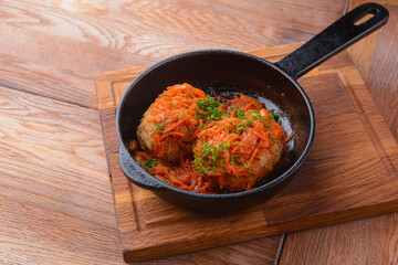 Stew with vegetables and meat - a simple stew in a pan. Served on a wooden board over rustic wooden background.