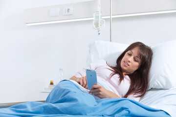 Female patient at the hospital and chatting with smartphone.