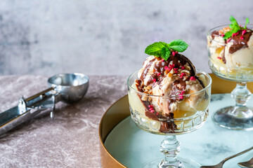 Ice cream dessert with poached pears and chocolate sauce garnished with fresh mint