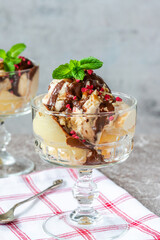 Ice cream dessert with poached pears and chocolate sauce garnished with fresh mint