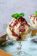 Ice cream dessert with poached pears and chocolate sauce garnished with fresh mint