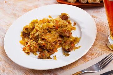 Naklejka premium Delicious meat dish – pork with stewed cabbage served on plate
