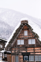 A house with thick snow covering the roof in Shirakawago Village, Shirakawago Japan.