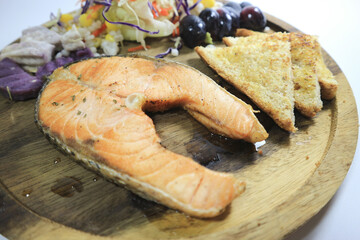 Grilled salmon steaks and fresh vegetables on a white background