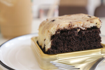 Chocolate brownies on a white plate in a coffee shop.