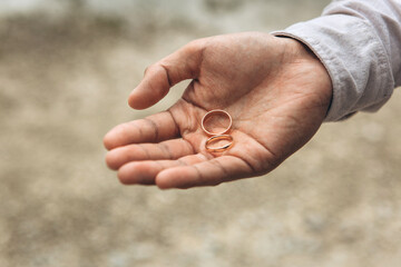 The groom holds a wedding ring.
