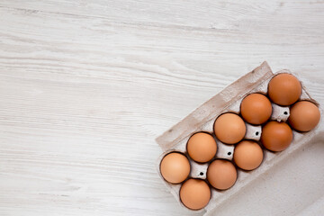 Raw Brown Eggs in a paper box, top view. Flat lay, overhead, from above. Copy space.