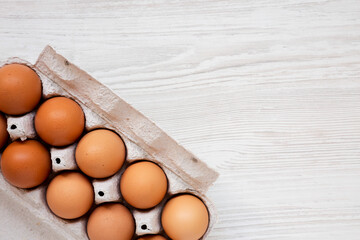 Raw Brown Eggs in a paper box, top view. Flat lay, overhead, from above. Space for text.