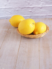 Lemon fruit in wicker basket on white wooden background, Copy space for text. ..