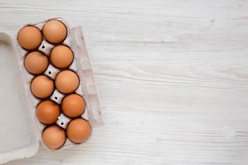 Raw Brown Eggs in a paper box, top view. Flat lay, overhead, from above. Copy space.