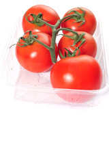 Fresh juicy tomatoes on vine in a plastic container on white isolated background. Fresh produce product.