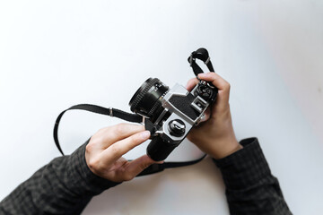 Vintage film camera in the man hands on a white background