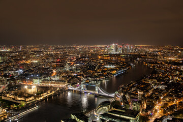 London at night, Aerial photograph of Tower Bridge and the River Thames at night leading to Canary Wharf and the banking district