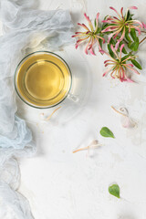 Obraz na płótnie Canvas A cup of jasmine tea and jasmine flowers on a white background.