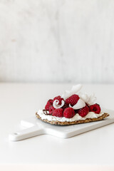 Snack with crispbread,cream cheese and fresh raspberries on white marble background. Healthy food concept.