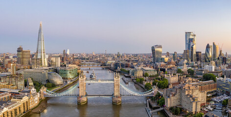 Aerial drone photograph of Tower Bridge and the River Thames at dusk with City Hall, The Shard and London City in the background. London England. 